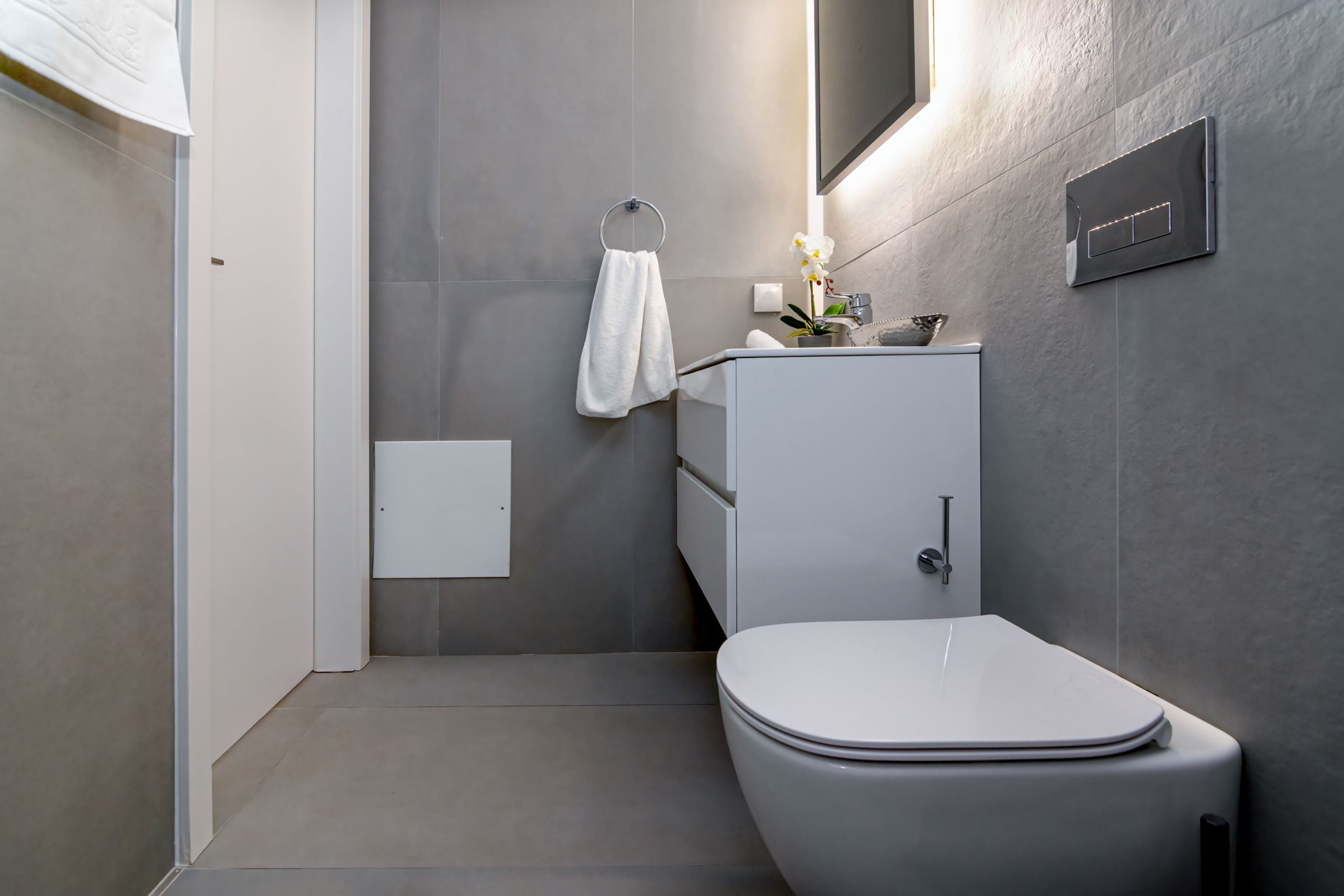 Une salle de bain moderne équipée de toilettes, d’un lavabo et d’un porte-serviettes.