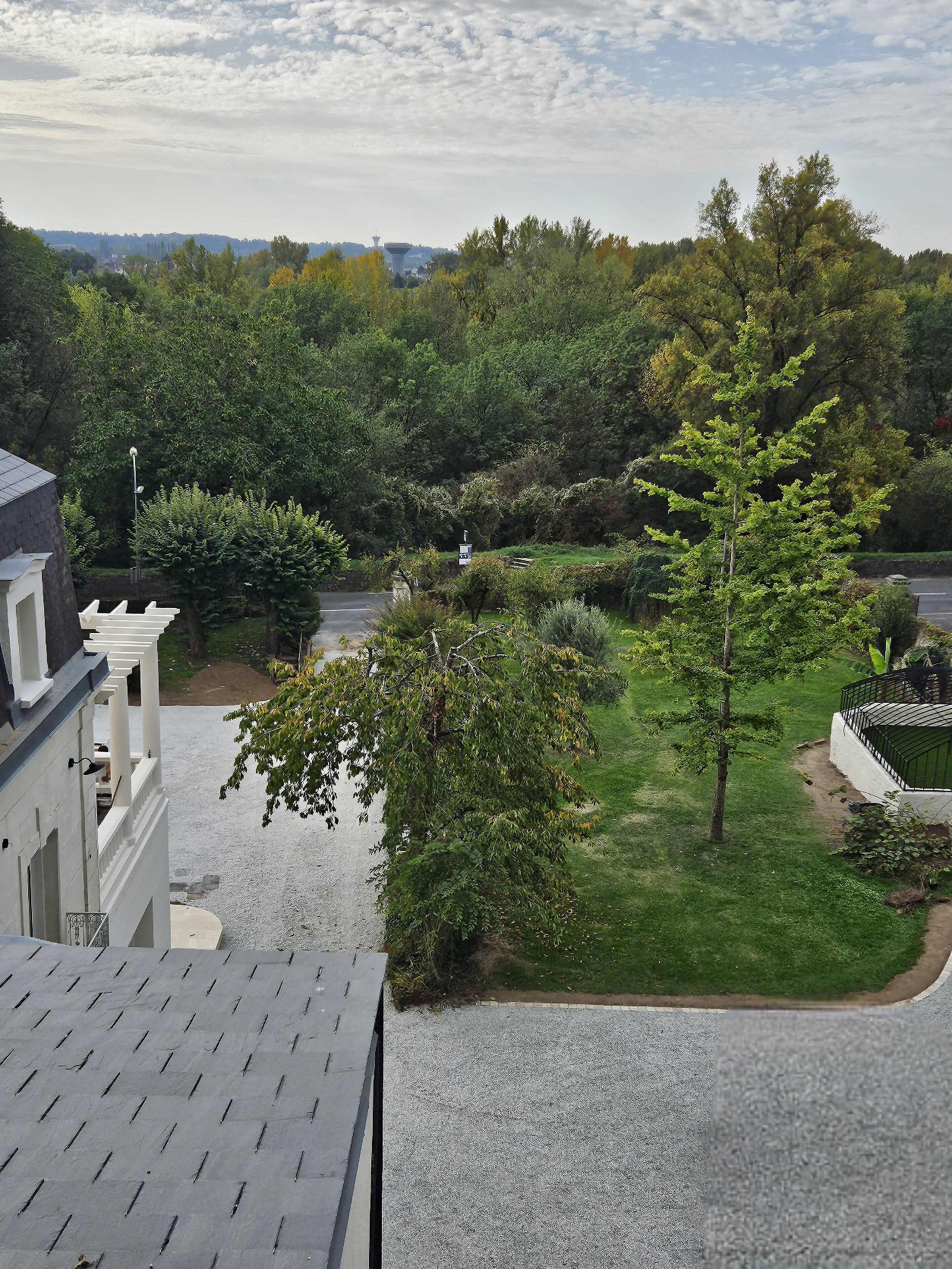 A residential area with a well-maintained lawn, a pathway, and a building with a white facade and columns.