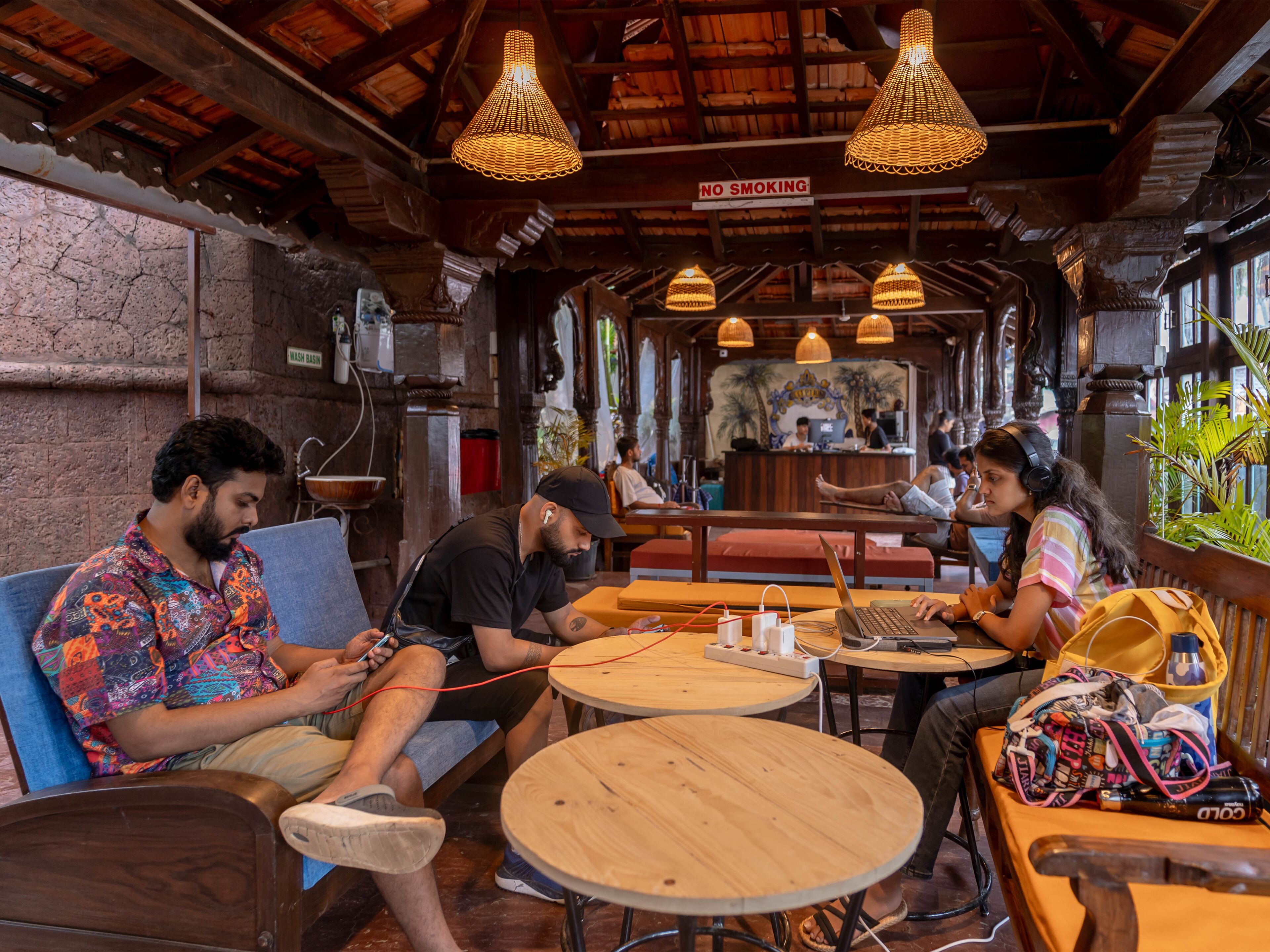 Un café acogedor con muebles de madera, mesas redondas e iluminación colgante.