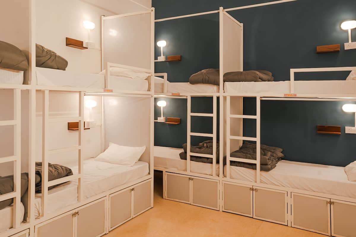 Habitación con literas de varios niveles, armarios empotrados e iluminación junto a la cama.