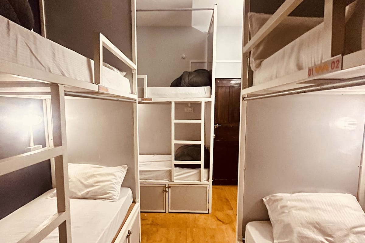 Un dormitorio compacto con literas y compartimentos de almacenamiento integrados.