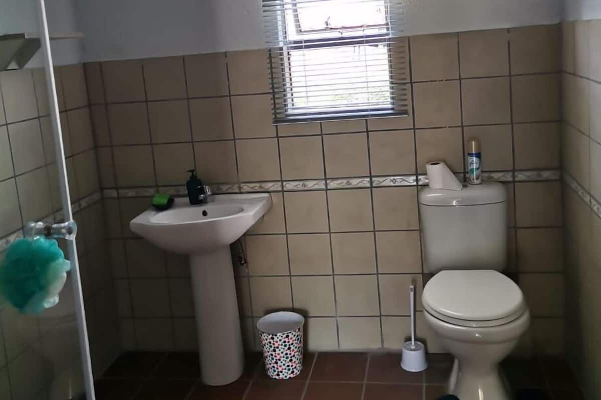 A small bathroom with a sink, toilet, and window.