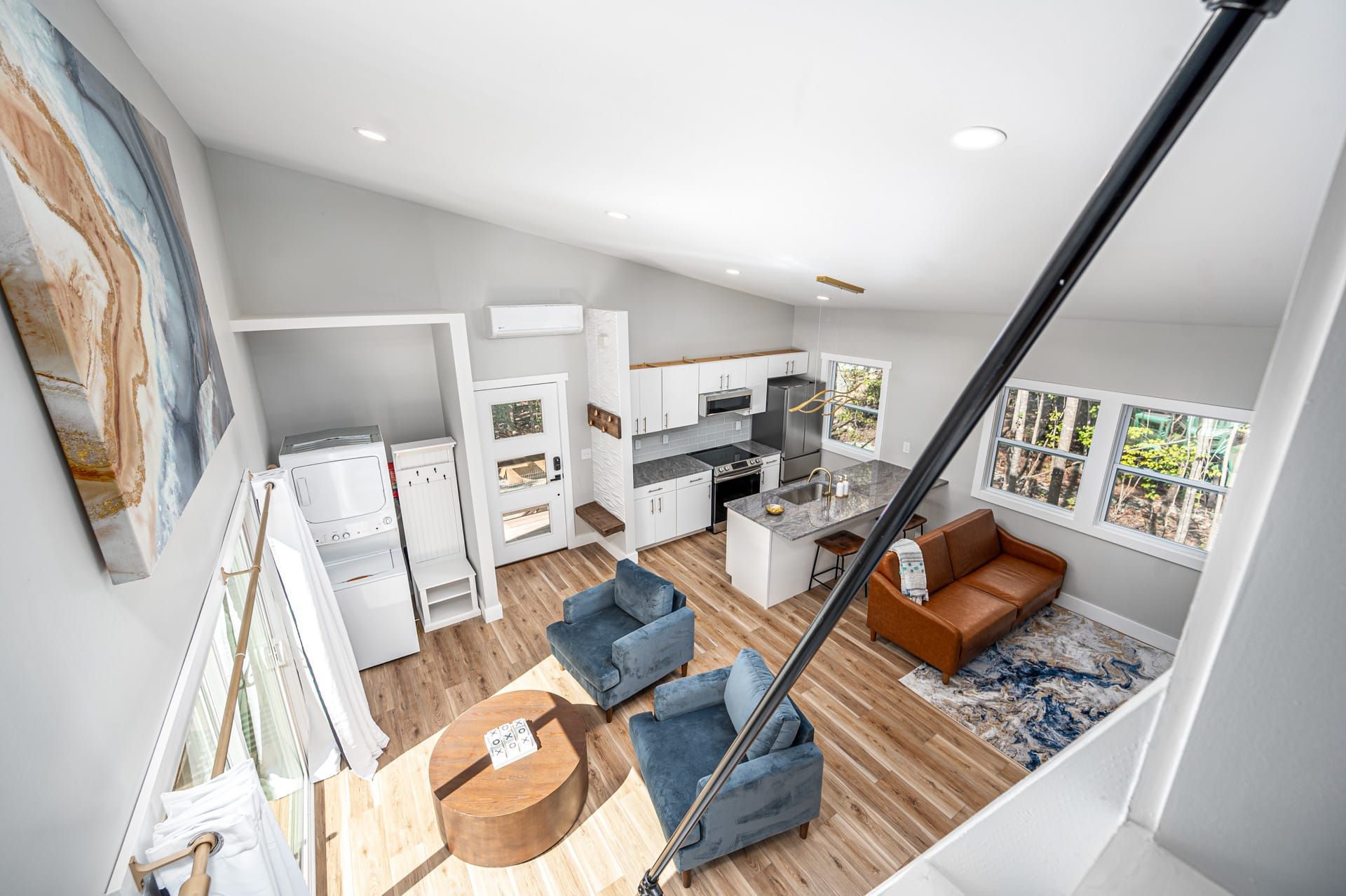 Een modern appartement met keuken, woonruimte en een trap.