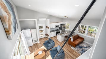 Een modern appartement met keuken, woonruimte en een trap.