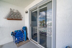 A room with a sliding glass door, a blue wheelchair, and a sailboat decoration on the wall.