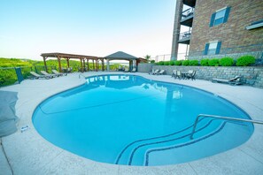 A swimming pool with lounge chairs and a gazebo.