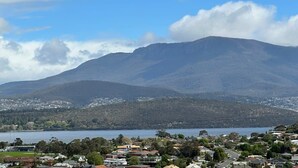 A mountainous landscape with a lake and residential buildings in the foreground.