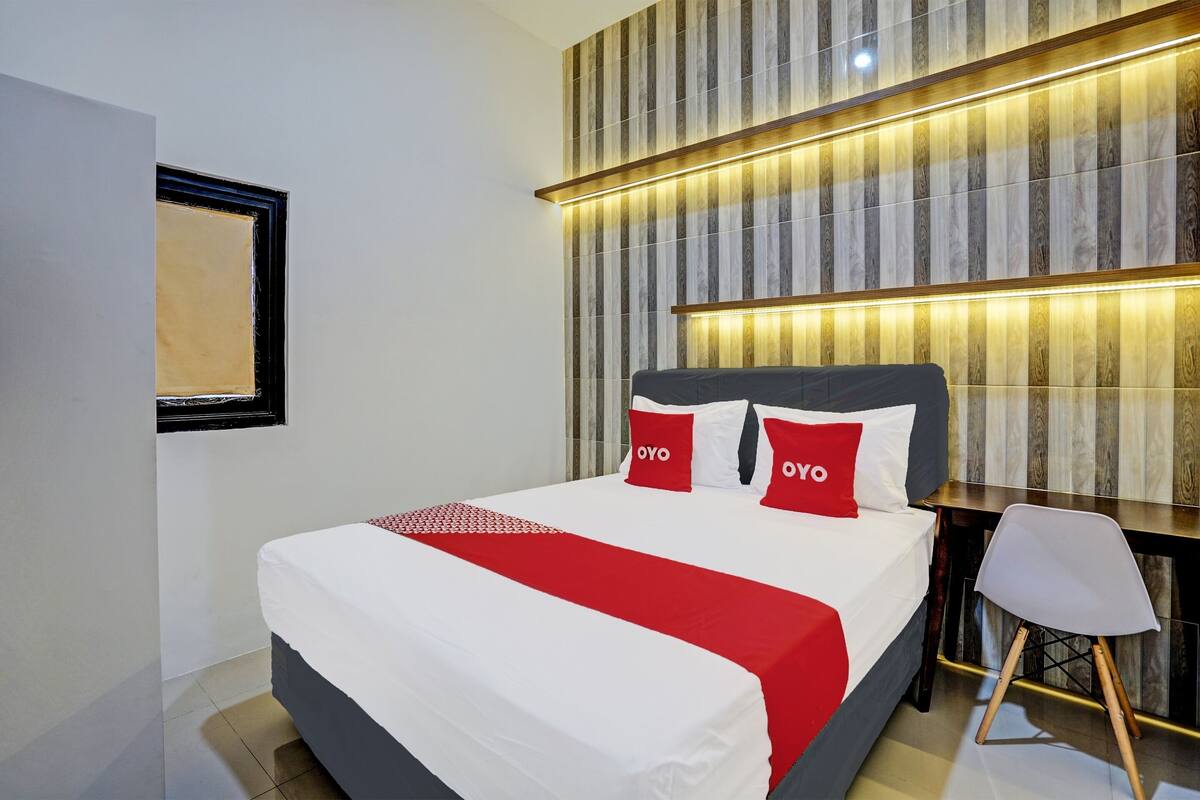 Ein modernes Hotelzimmer mit einem großen Bett, einem Schreibtisch und einem Sessel.