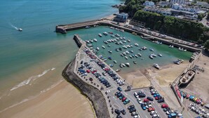 A coastal marina with boats, a parking lot, and buildings along the shore. - 17 Beach Court - 2 Bed Apartment - Saundersfoot (Saundersfoot)