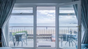 A room with a large sliding glass door leading to a balcony with a view of the sea. - 17 Beach Court - 2 Bed Apartment - Saundersfoot (Saundersfoot)