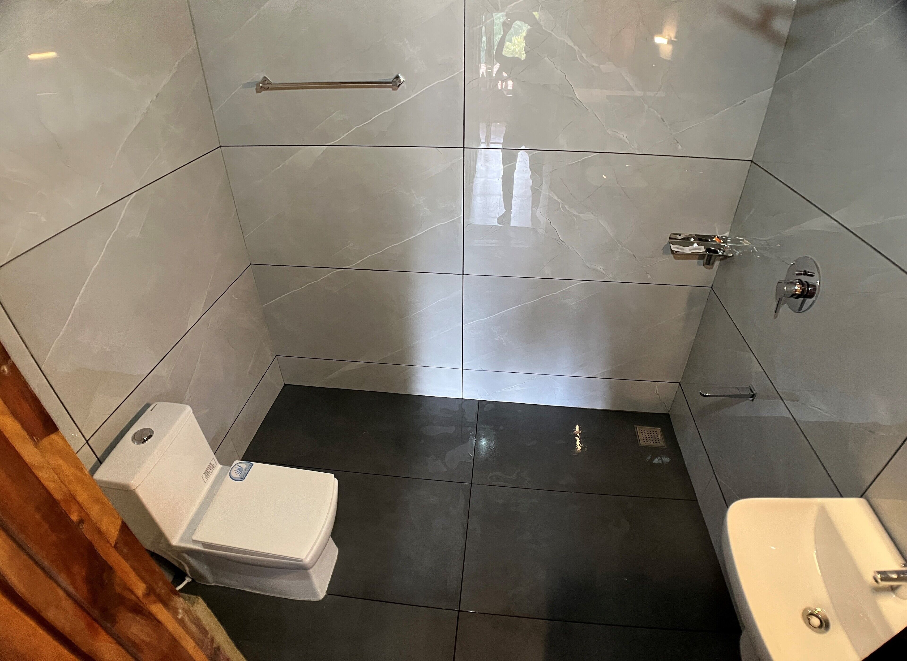 A modern bathroom with a toilet, sink, and shower area.
