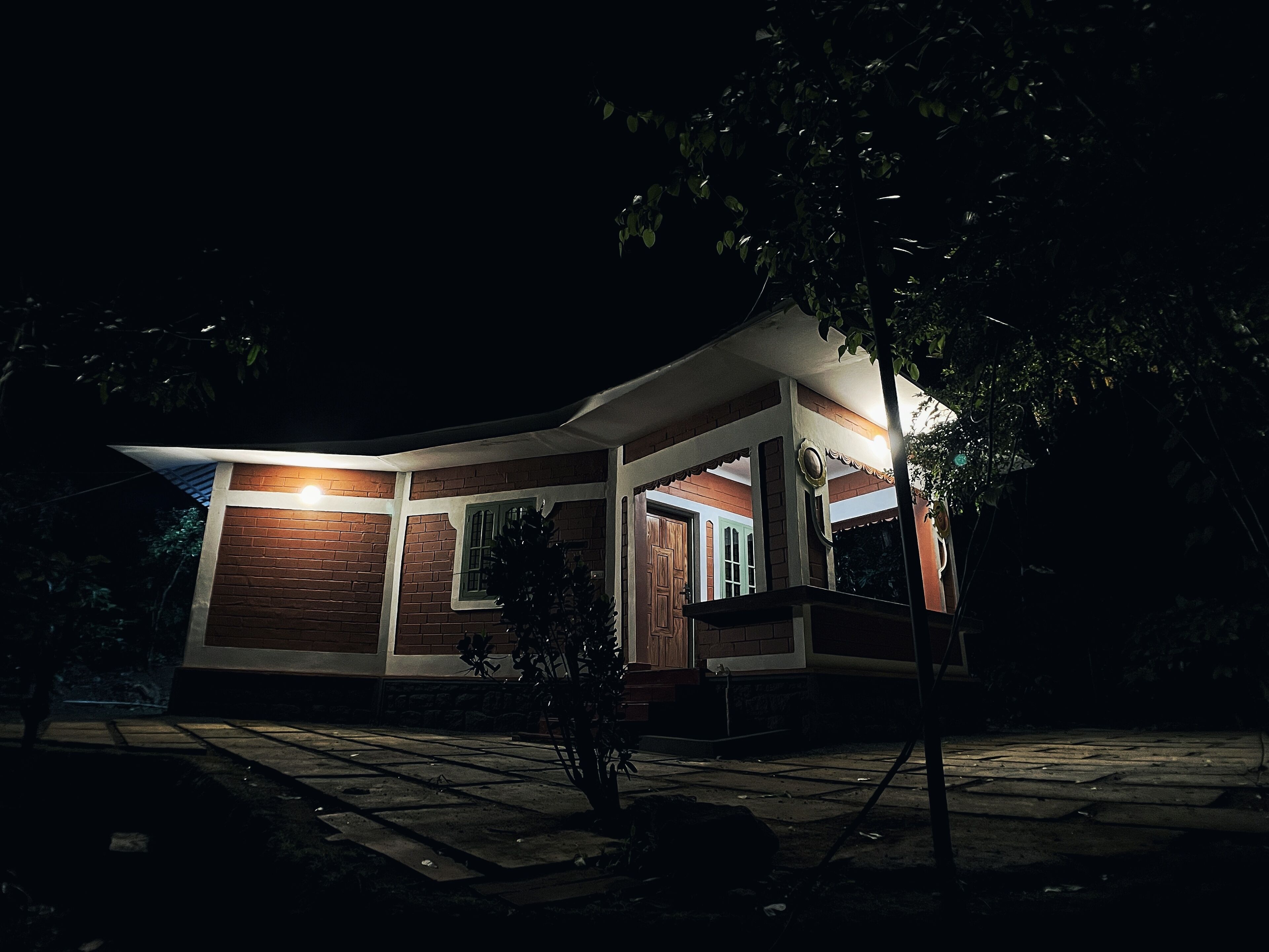 Una casa moderna con fachada de ladrillo, un porche y una entrada bien iluminada.