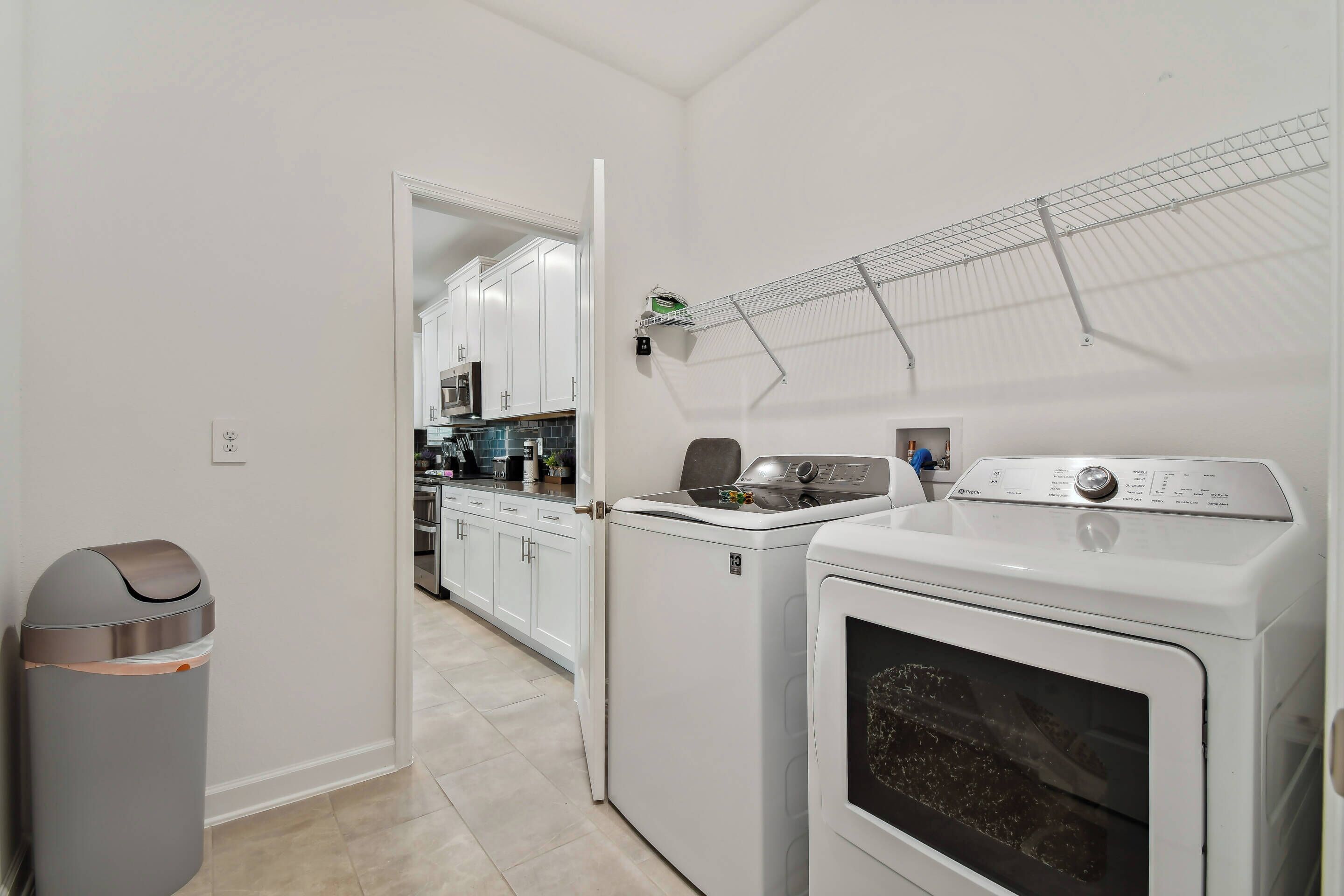 A laundry area with a washing machine, dryer, and a drying rack.