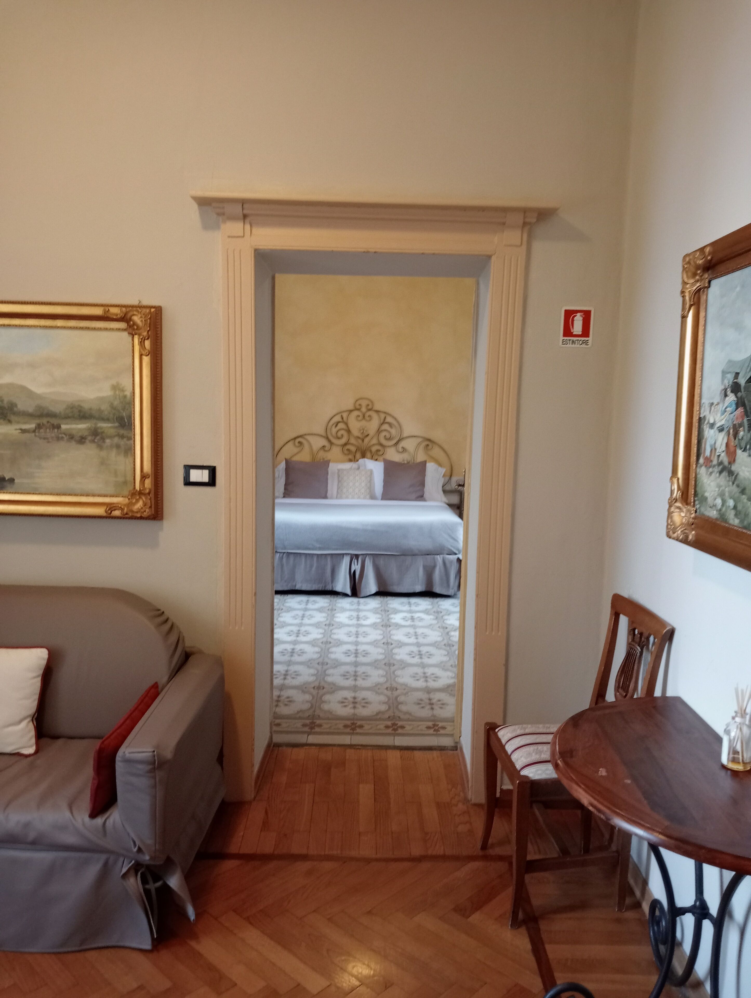 Hotellihuone, jossa on sänky, sohva, ruokapöytä ja tuoli.
