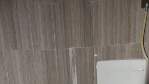 A bathroom with a toilet, a shower, and a sink.