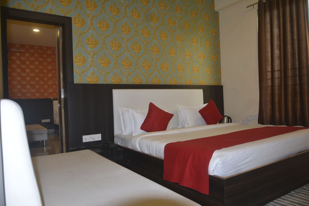 Una habitación de hotel con una cama, una mesita de noche y un espejo.