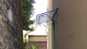 Une ruelle étroite avec un escalier métallique menant à un immeuble.