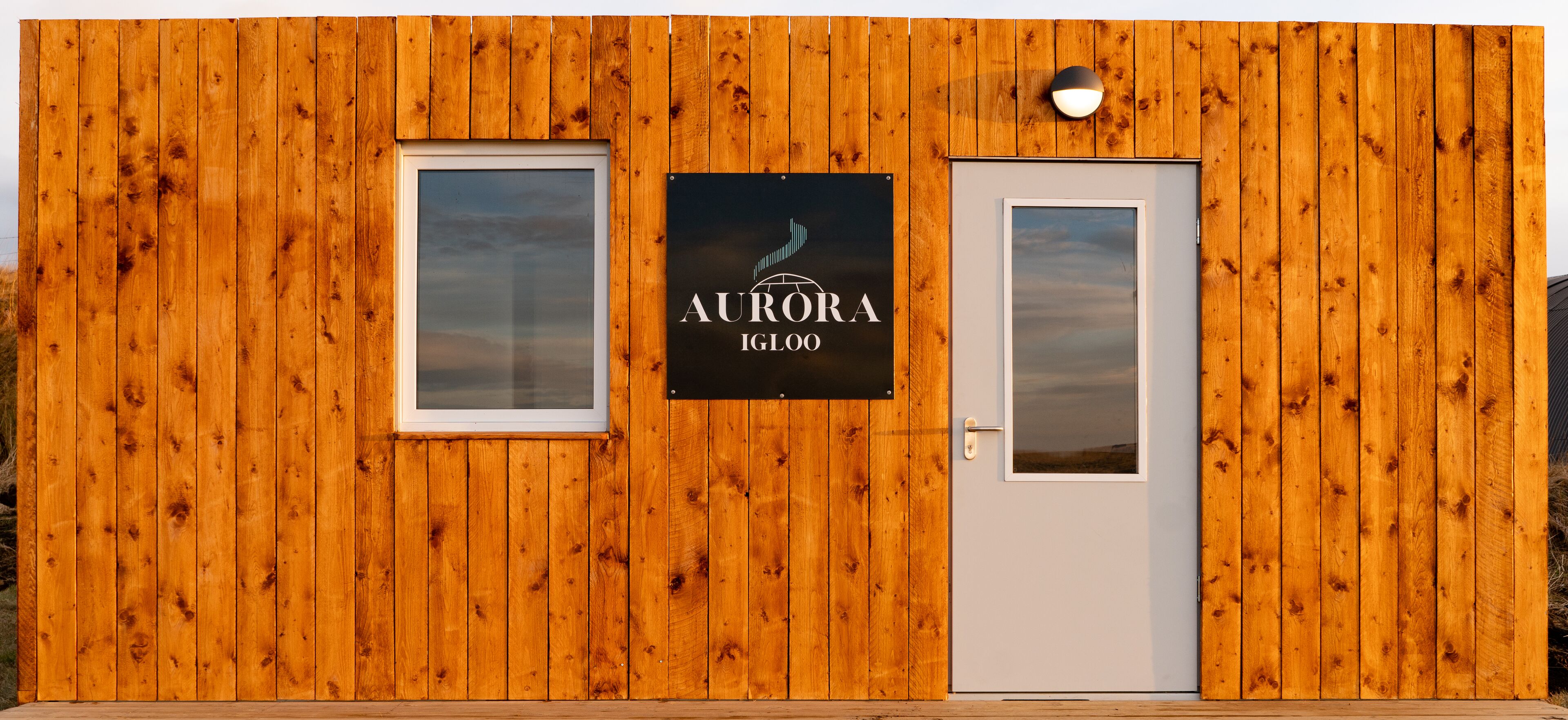 A wooden building with a sign that reads "AURORA IGLOO".