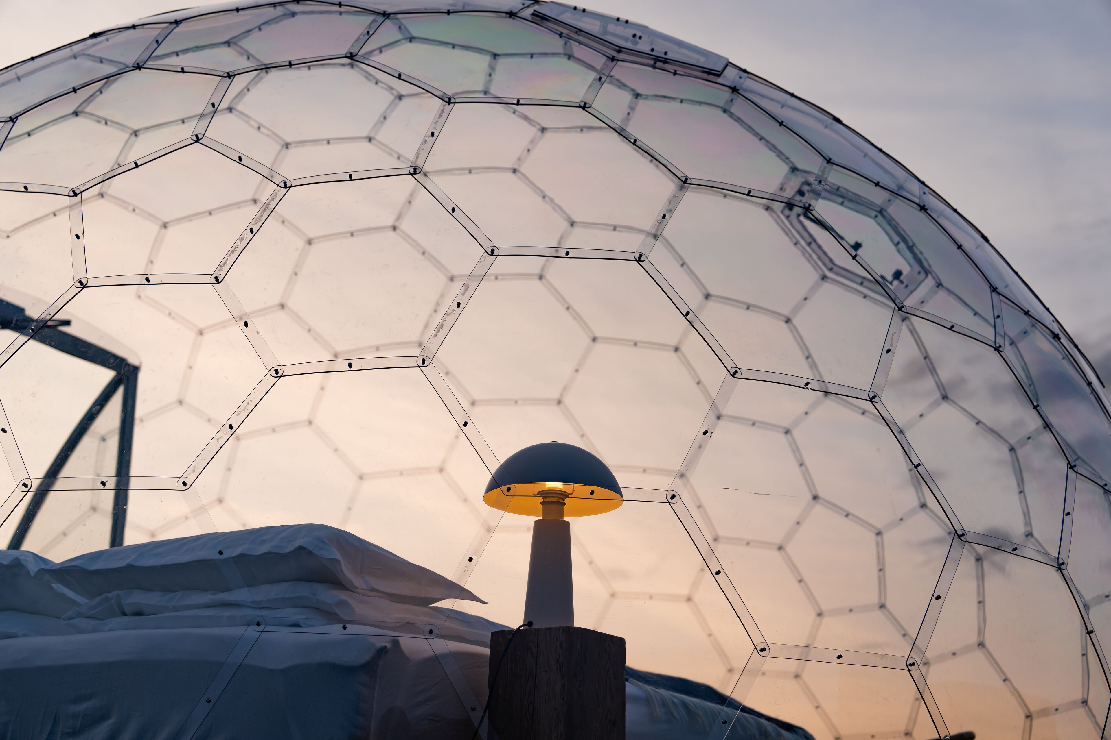 Une structure en forme de dôme géodésique, avec un lampadaire au premier plan.