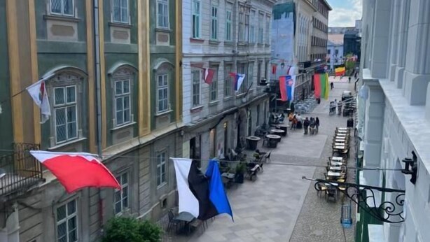 A courtyard with outdoor seating, surrounded by buildings with multiple windows and balconies. - VISAJ Downtown (Timisoara)