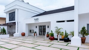 A modern building with a white facade, a café named "Café @ No.8", and a sign that reads "NOO". - No. 8 Boutique Hotel (Ilorin)