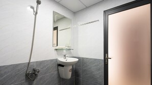 A bathroom with a shower, sink, and mirror. - Loc Phat Hotel (Ho Chi Minh City)