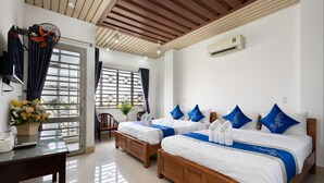 A hotel room with two wooden beds, a large window with a view, a ceiling fan, and an air conditioning unit. - Loc Phat Hotel (Ho Chi Minh City)