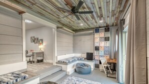 Een moderne slaapkamer met een hoogslaper, ingebouwde opbergruimte en een plafondventilator.