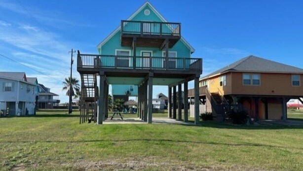 A two-story house with a balcony, surrounded by a grassy yard and other houses. - Budget friendly, fun, great location & clean! You found your next vacation home. (Surfside Beach)