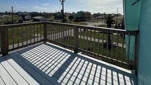 A balcony with a view of a residential area and a clear sky. - Budget friendly, fun, great location & clean! You found your next vacation home. (Surfside Beach)
