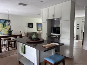 Enjoy cooking in this well-equipped kitchen with a central island, sink, and dining area.