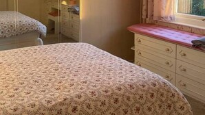 A bedroom with a bed, a dresser, a mirror, and a window with curtains. - Immaculate 3-bed House in Durham Near Sedgefield (Trimdon Station)