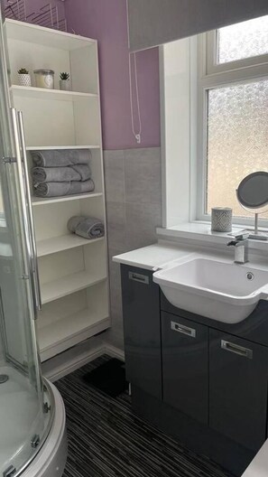Huis | Badkamer | Een douche, een haardroger, handdoeken