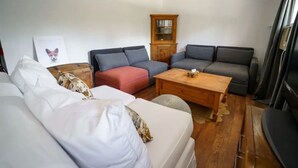 Een gezellige woonkamer met een zithoek, een houten salontafel en een kast.