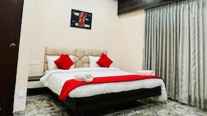 A bedroom with a bed, a ceiling fan, an air conditioning unit, and a patterned floor. - Igatpuri Hill Retreat (Igatpuri)