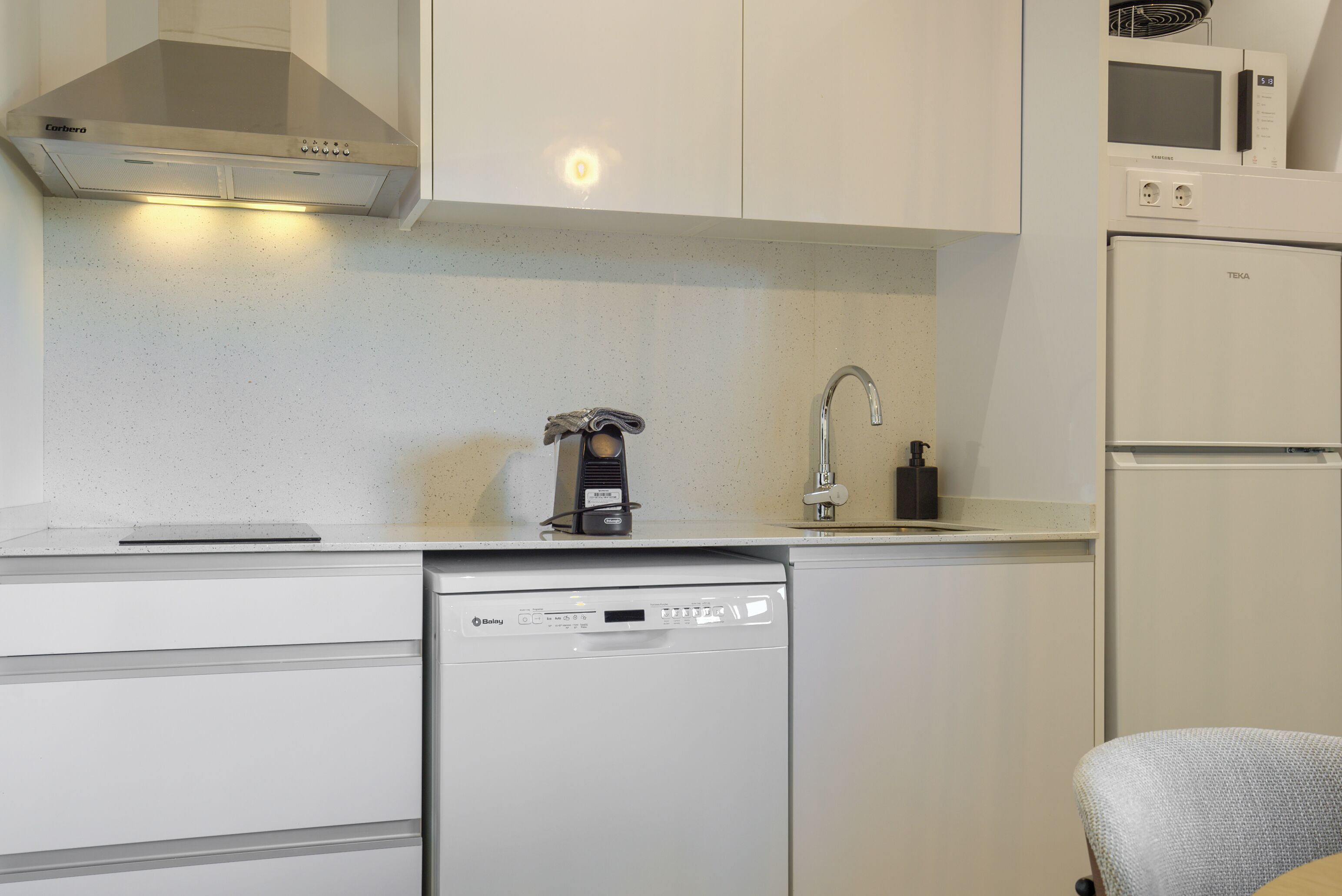 Una cocina compacta con lavavajillas Bosch, microondas y horno empotrado.