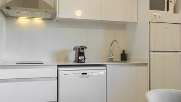 Una cocina compacta con lavavajillas Bosch, microondas y horno empotrado.