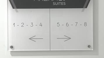 Señalización de 'ARENA 20 SUITES' con los números de habitación 1-4 y 5-8, mostrando la distribución de las suites.