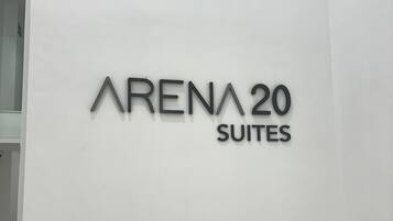 Un letrero que dice "ARENA 20 SUITES" sobre una pared blanca.