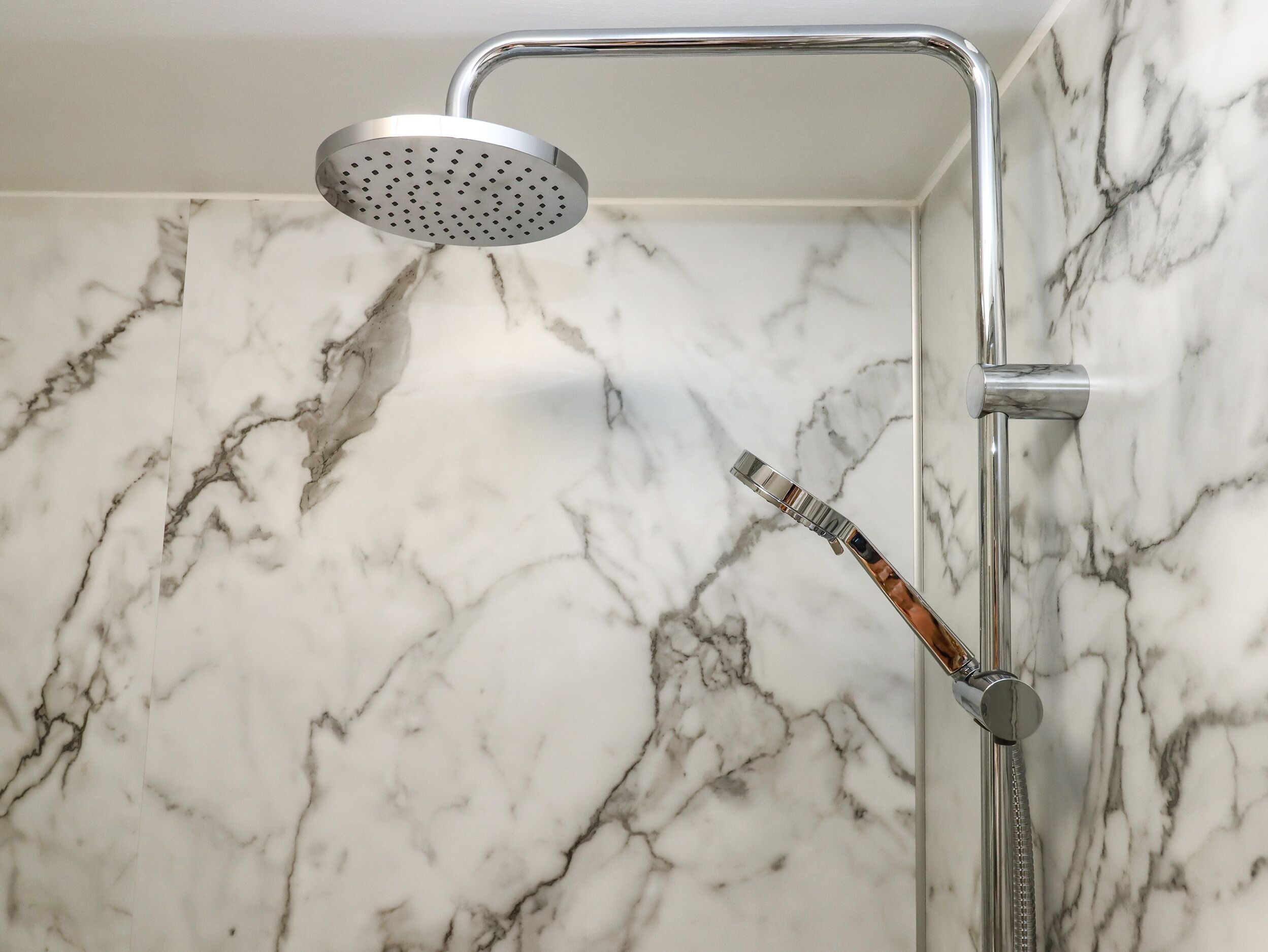 Eine moderne Dusche mit Handbrause und Duschhandstück.