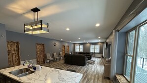 A modern kitchen with a marble countertop and a dining area with a built-in bench. - Big Chip - 2 is in the heart of the Chippewa Flowage 20 minutes from Hayward, WI (Hayward)