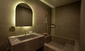 Un baño moderno con un espejo grande, un lavabo y una ducha.