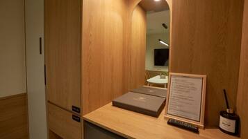 Una habitación con estructura de madera, un escritorio, un control remoto y una botella.