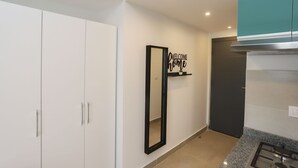 A modern kitchen with a gas stove, white cabinets, and a 'Welcome' sign on the wall. - Prime Inn 10th of Ramadan (Tenth of Ramadan City)