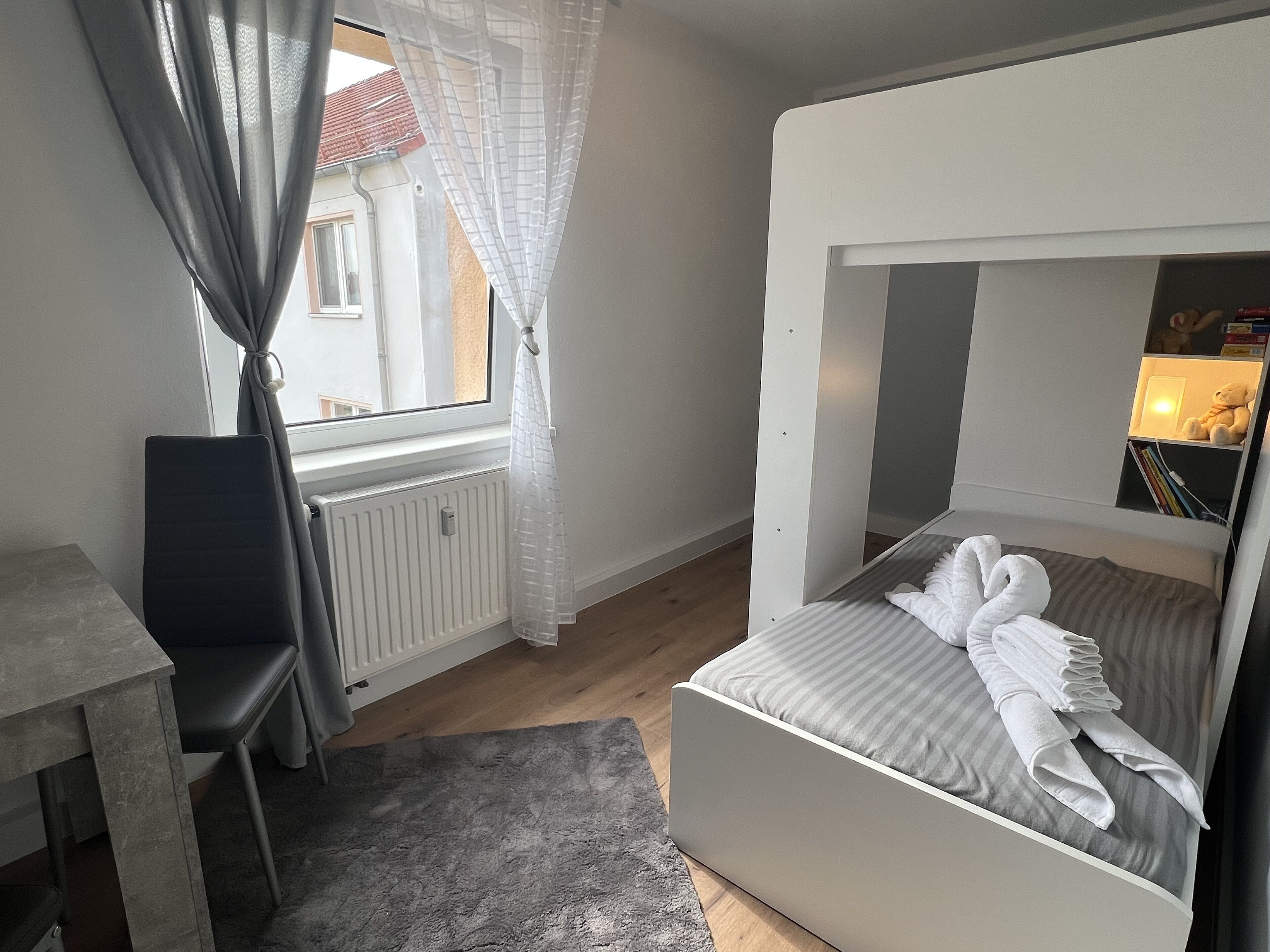 Ein Schlafzimmer mit Etagenbett, Schreibtisch und Stuhl.