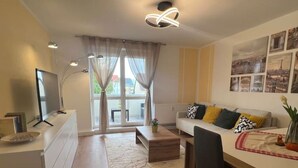 Ein modernes Wohnzimmer mit einer Couch, einem Couchtisch und einem Essbereich mit Tisch und Stühlen.