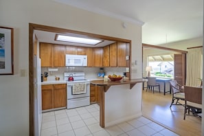 Enjoy meals in the kitchen with a dining area nearby, featuring a table and chairs.