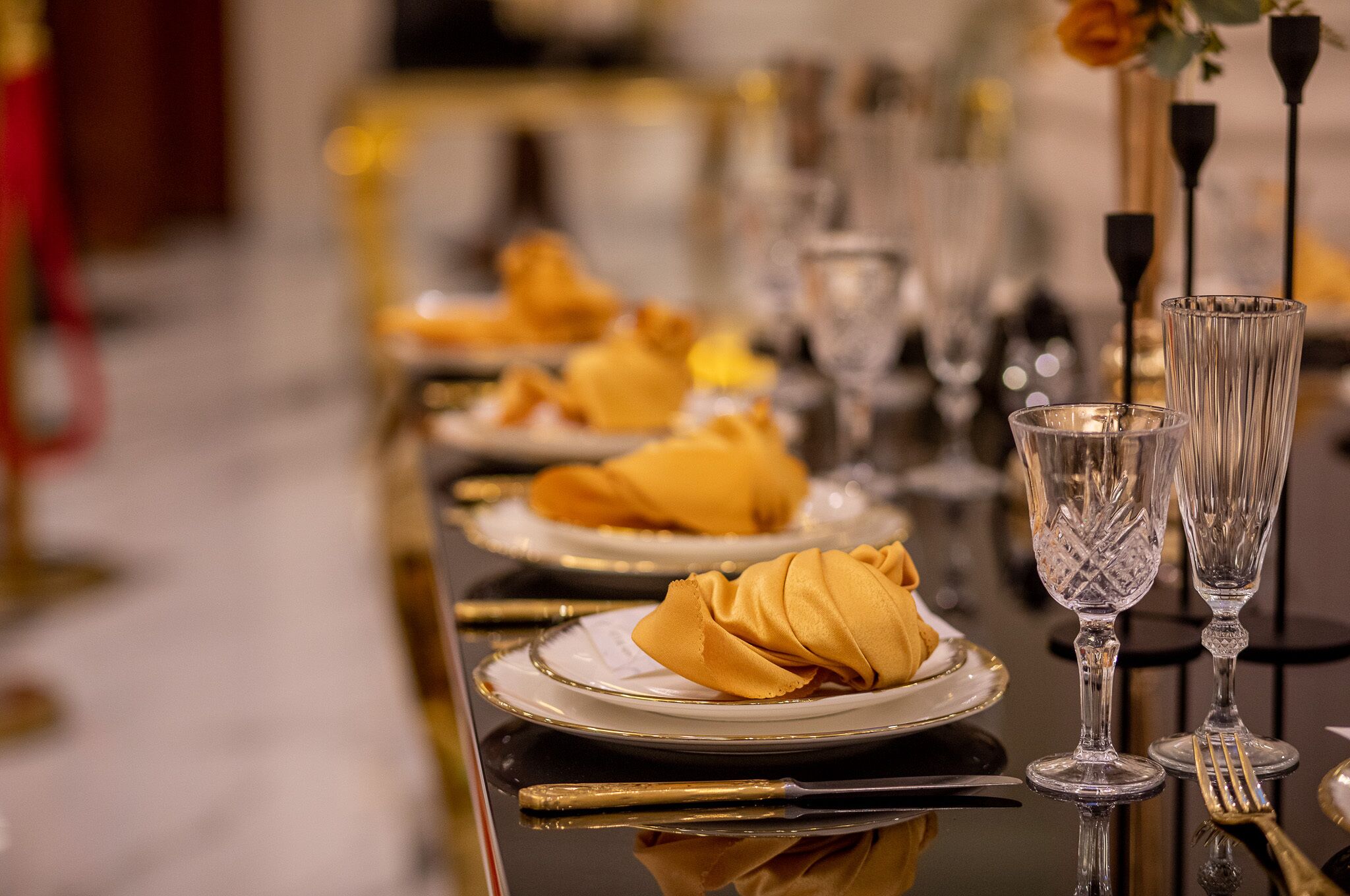 A table set with plates, napkins, and clear glassware.