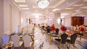 A banquet hall with long tables, chandeliers, and elegant chairs. - THE DREAMS HOTEL (Douala)