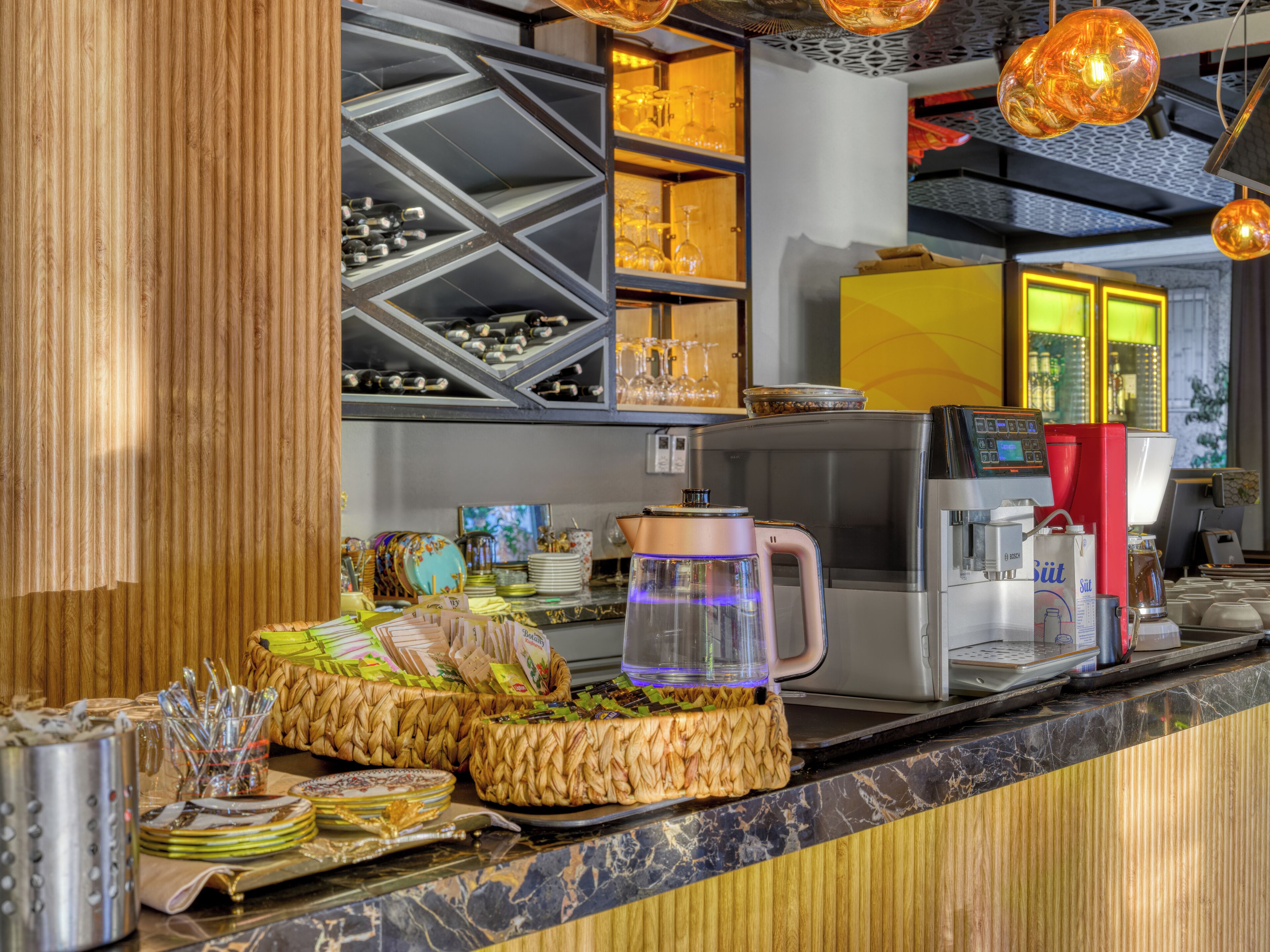 Un espace bar équipé d’une machine à café, d’un réfrigérateur à vin et de divers accessoires de bar.